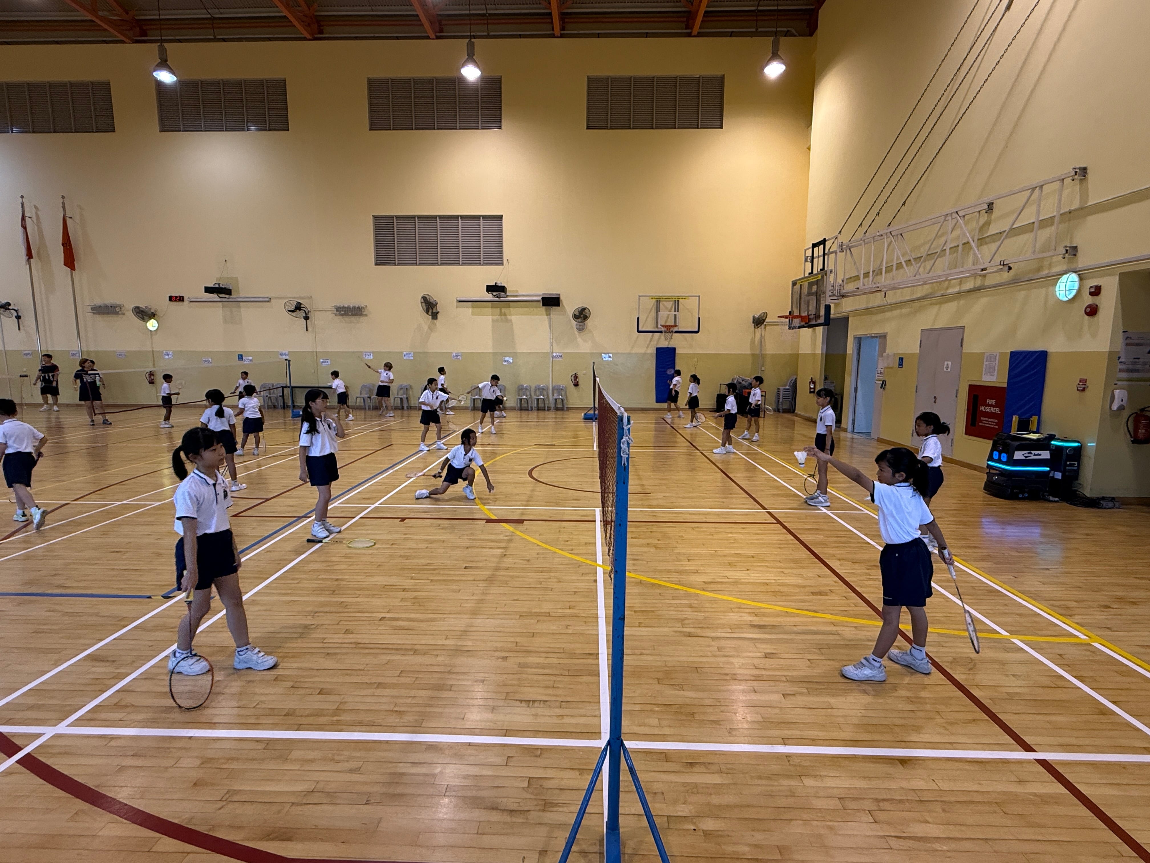 Students playing badminton in the school hall